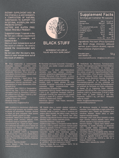 The back of a "BLACK STUFF" dietary supplement package featuring product details in English, Estonian, Finnish, Swedish, Czech, German, and Latvian. The text highlights the supplement’s high polyphenol and antioxidant content, usage instructions, nutritional information per 100g and per capsule, ingredient list (pine bark, birch chaga extract, silicon dioxide, plant-based capsule), storage instructions, manufacturer and distributor details, and a circular logo with a stylized tree at the center