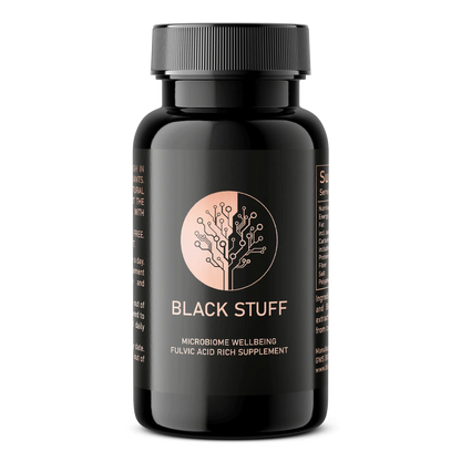 A black plastic bottle with a black screw cap labeled "BLACK STUFF." The label features a copper-colored circular logo resembling a stylized tree made of circuit lines and includes the text "MICROBIOME WELLBEING FULVIC ACID RICH SUPPLEMENT."