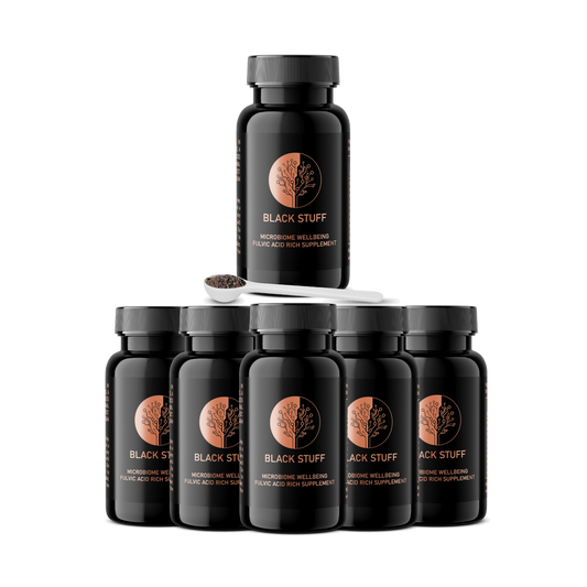 A stack of six bottles of BLACK STUFF supplement powder, with the brand logo visible on the label.