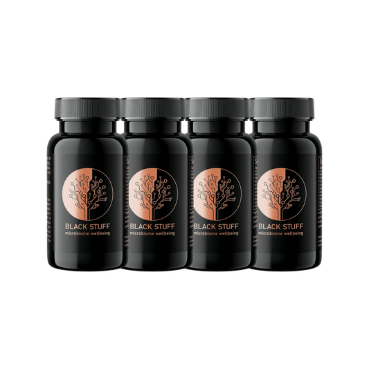 Four bottles of BLACK STUFF capsules arranged side by side against a white background.